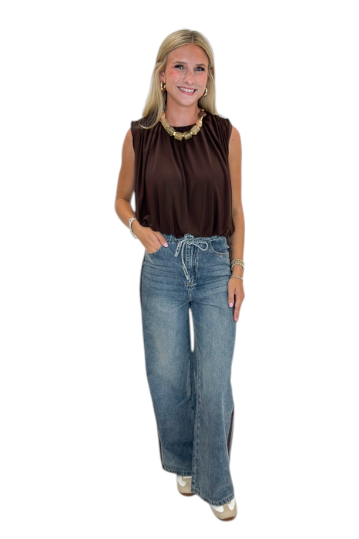 Front view of woman wearing Swagger Boutique’s Brown Mesh Bubble Hem Top with jeans against white studio background.