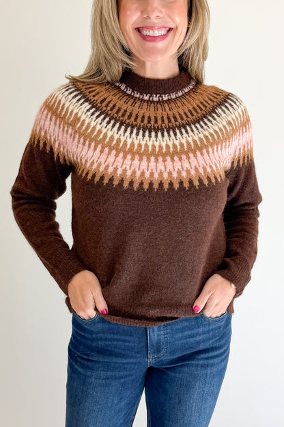 Front detail view of woman wearing Swagger Boutique’s Brown &amp; Pink Fair Isle Sweater with jeans against white studio background.
