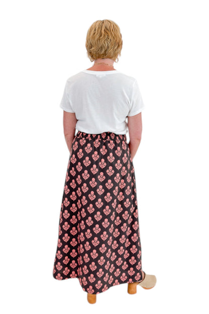Back view of woman wearing Swagger Boutique’s Brown &amp; Pink Floral Print Skirt with top against white studio background.