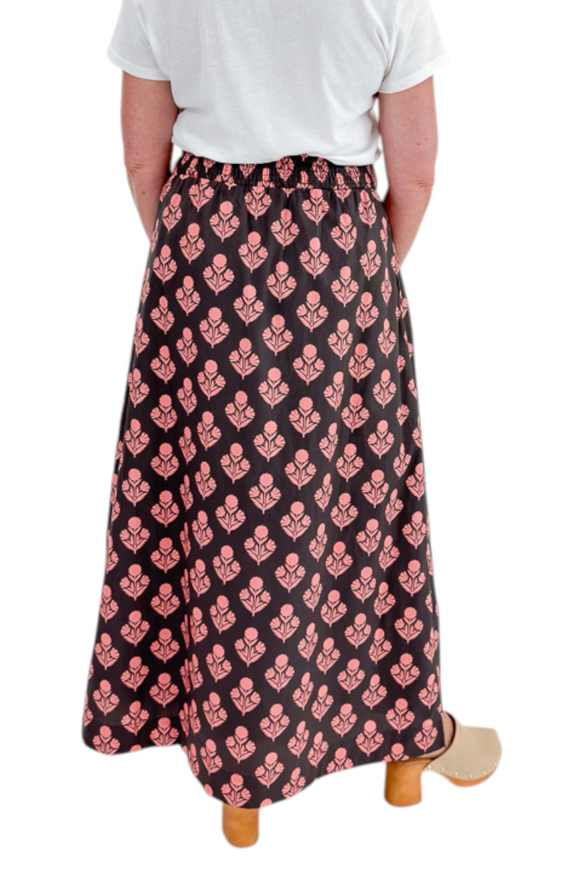 Back view of woman wearing Swagger Boutique’s Brown &amp; Pink Floral Print Skirt with top against white studio background.