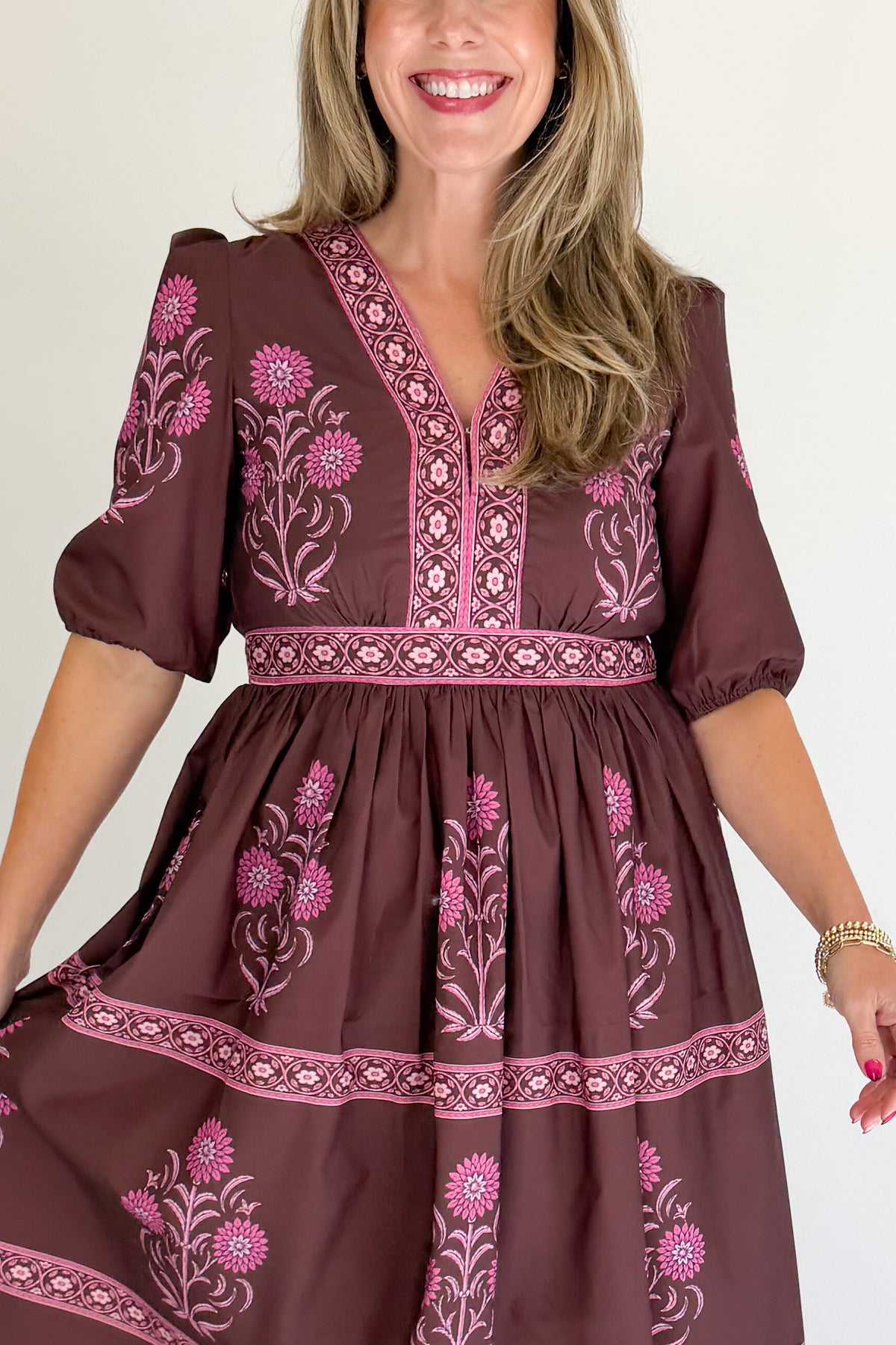 Front detail view of woman wearing Swagger Boutique’s Brown &amp; Pink Printed Midi Dress with heels against white studio background.