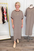 Front view of woman wearing Swagger Boutique’s Brown Striped Midi Dress by Entro with clothing hanging in the background.