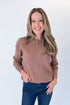 Front view of woman wearing Swagger Boutique’s Brown & Taupe Double Band Sweater with jeans against white studio background.