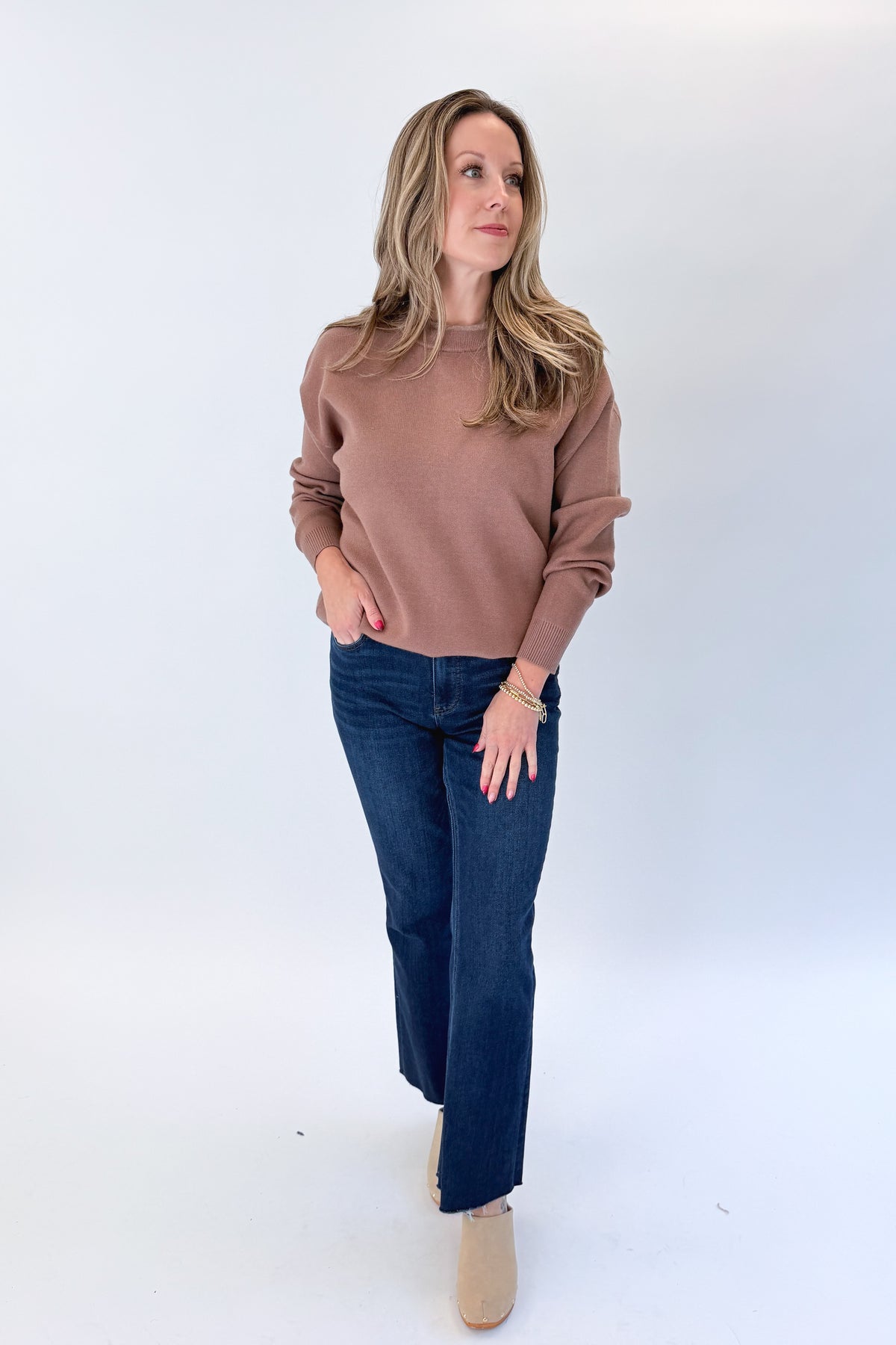 Front view of woman wearing Swagger Boutique’s Brown &amp; Taupe Double Band Sweater with jeans against white studio background.