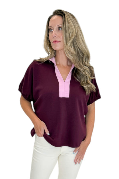 Front view of woman wearing Swagger Boutique’s Burgundy &amp; Pink Contrast Dolman Sleeve Top by Entro with jeans against white studio background.