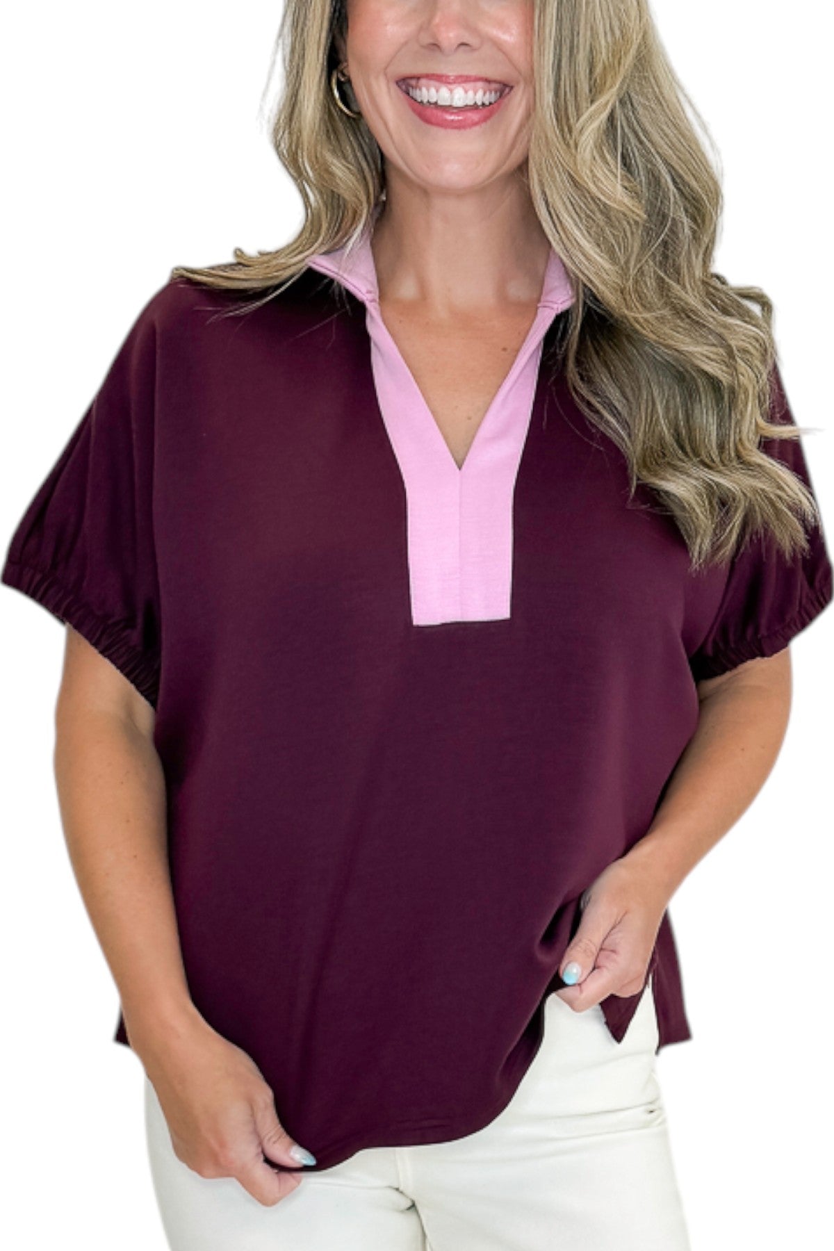 Front detail view of woman wearing Swagger Boutique’s Burgundy &amp; Pink Contrast Dolman Sleeve Top by Entro with jeans against white studio background.