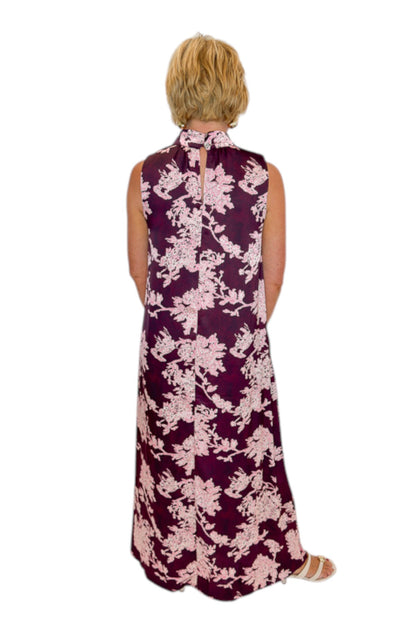 Back view of woman wearing Swagger Boutique’s Burgundy &amp; Pink Printed Maxi Dress by Entro with sandals against white studio background.