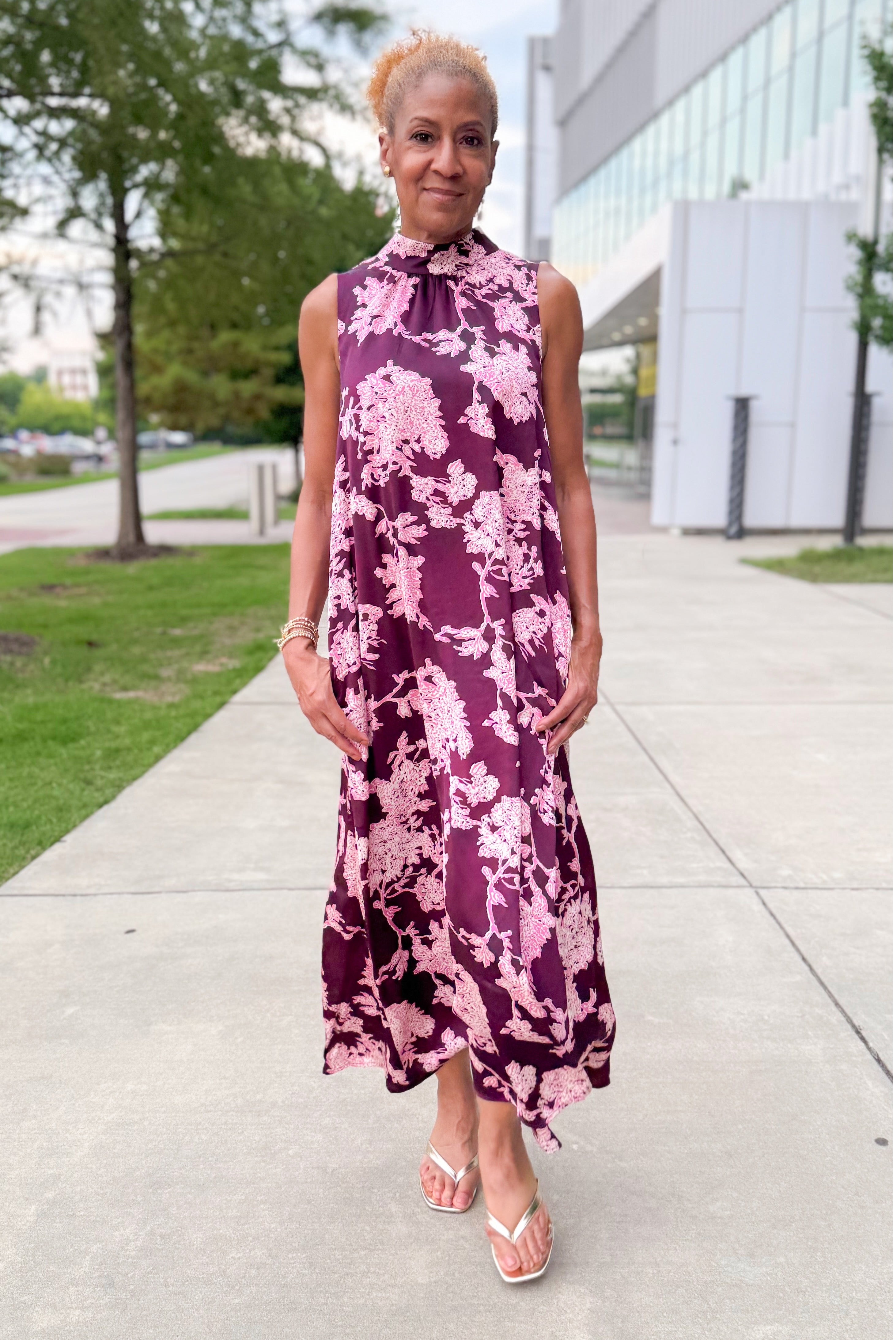 Front view of woman wearing Swagger Boutique’s Burgundy &amp; Pink Printed Maxi Dress by Entro with sandals walking outside.