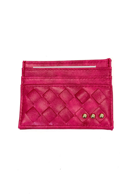 A bright pink woven leather card holder wallet with gold-tone studs, shown flat against a plain white background.