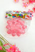 Packaged pink fidget toys with colorful label on a white background with pink flowers.
