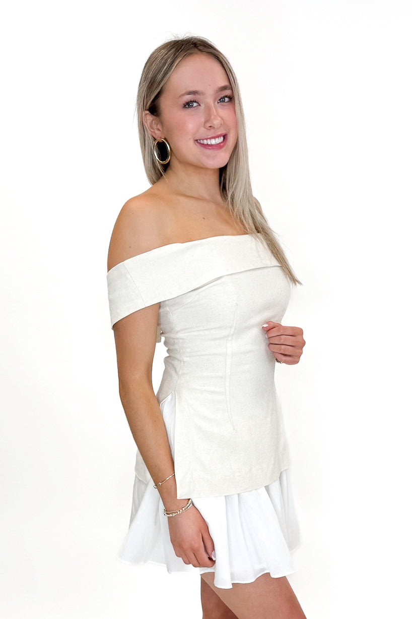 Side view of woman wearing Oatmeal Off The Shoulder Layered Dress against white studio background.