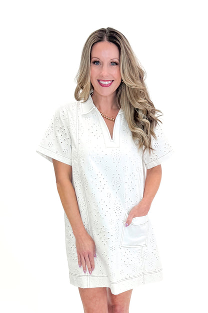Front view of woman wearing Cream Eyelet Pocket Detail Dress with sandals against white studio background.
