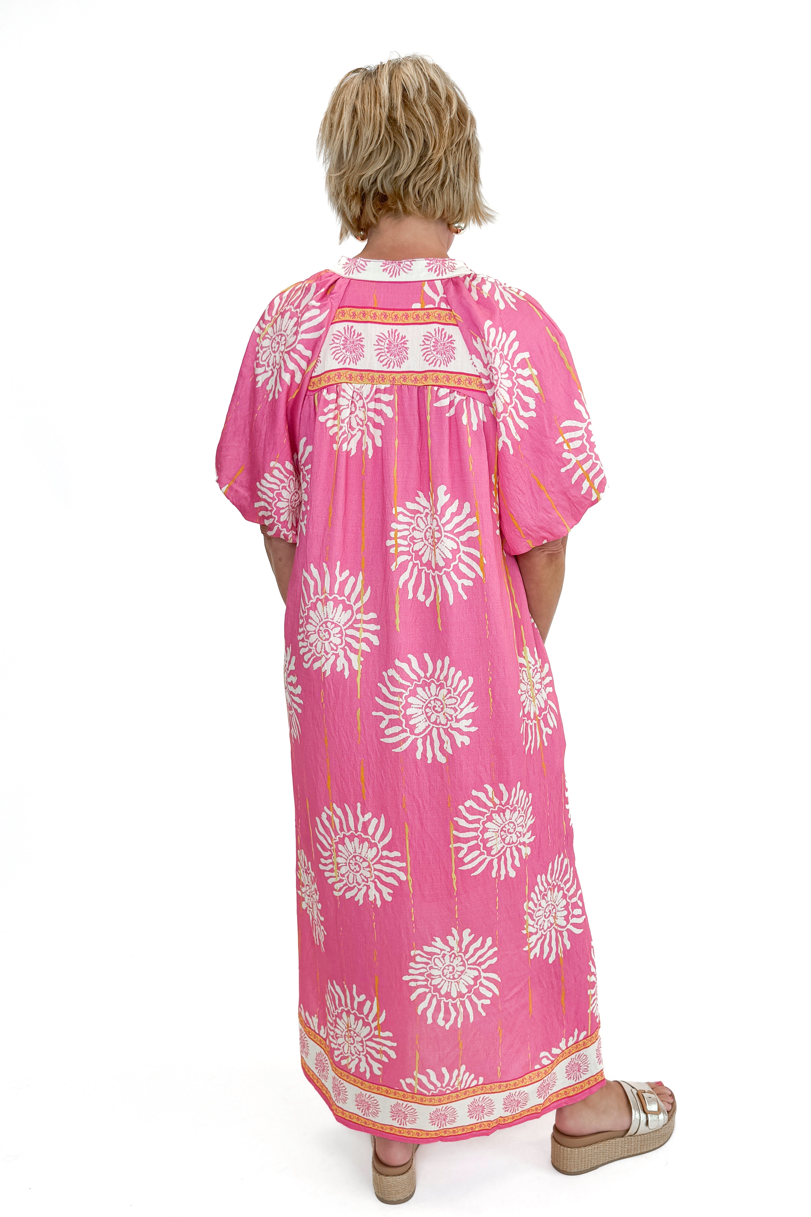 Back view of woman wearing Pink Printed Midi Dress against white studio background.