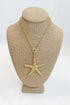 Gold starfish pendant necklace on a mannequin bust with a white background