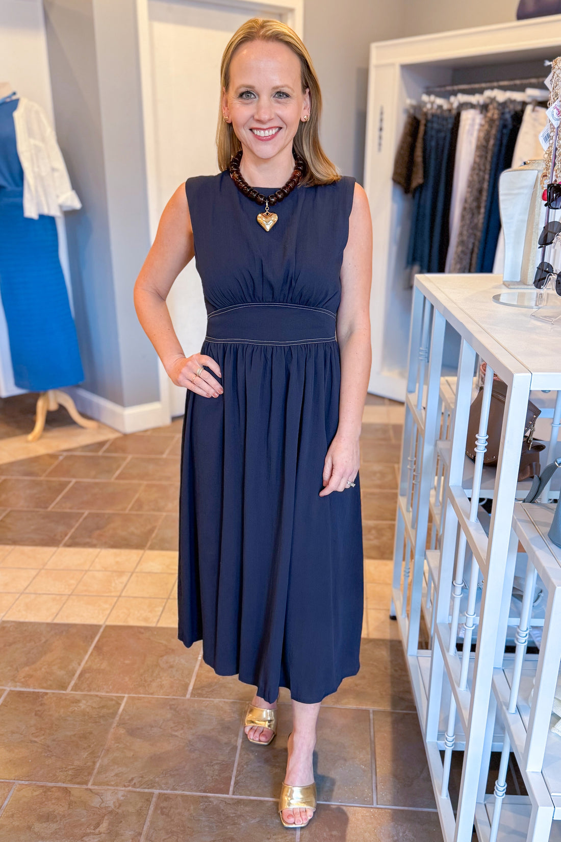 Front view of woman wearing Navy Stitch Waist Mid Dress at a boutique.