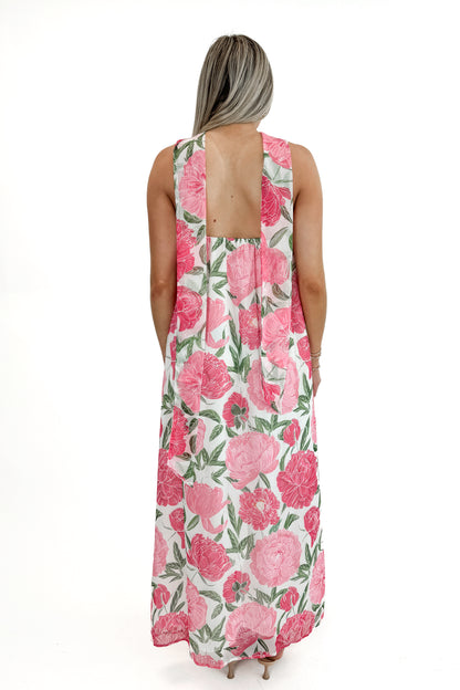 Back view of woman wearing Pink Floral Maxi Dress With Convertible Scarf against white studio background.