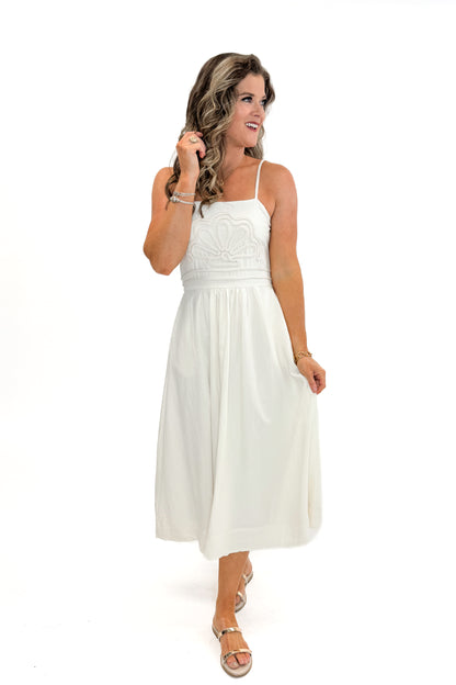 Front view of woman wearing Cream Shell Embroidered Midi Dress by TCEC with gold bar sandals against white studio background.
