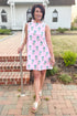 Front view of woman wearing Pink Floral Print Tie Back Dress standing outside.