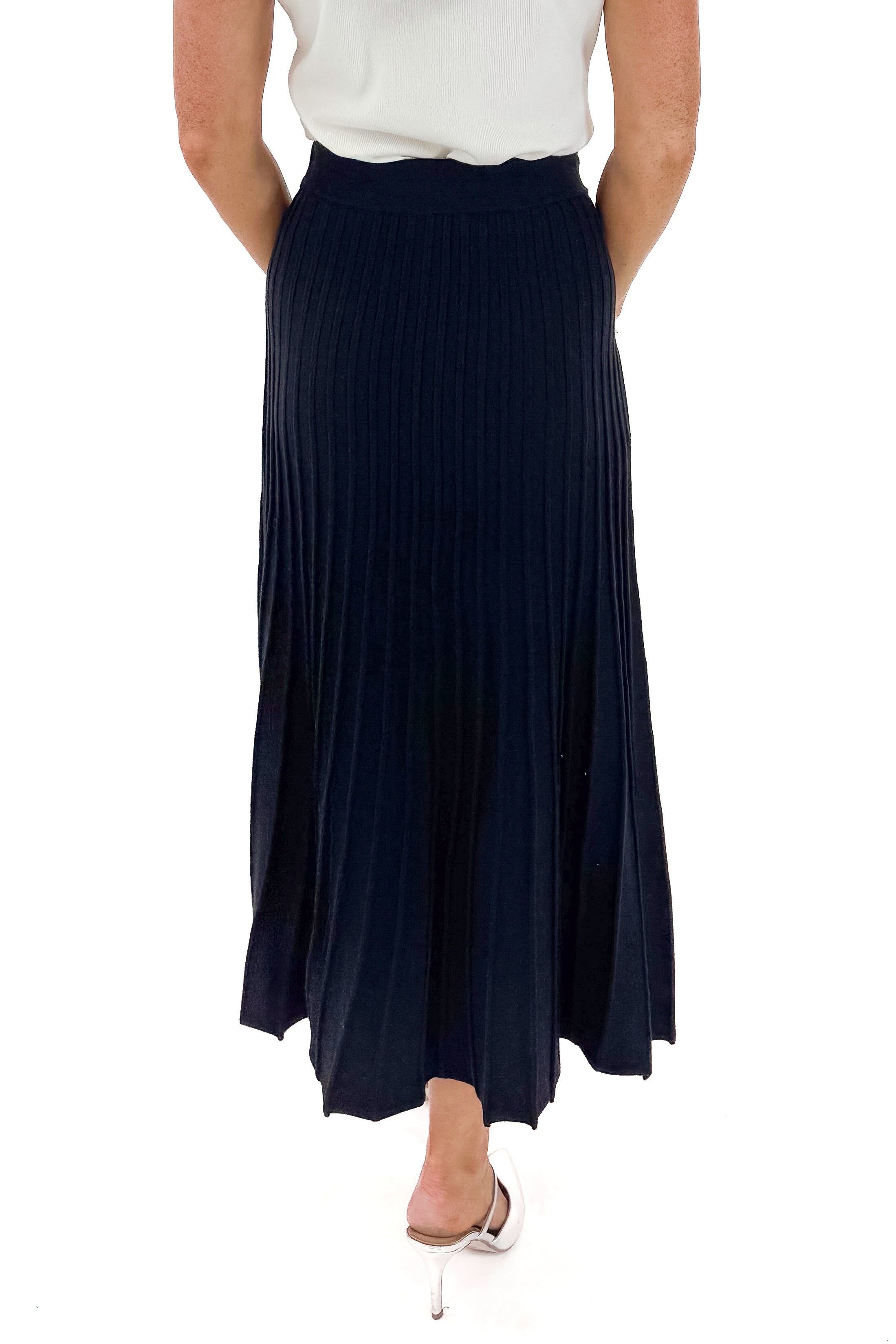 Back view of woman wearing Off White Pearl Detail Mock Neck Top with Black Pleated Sweater Skirt against white studio background.