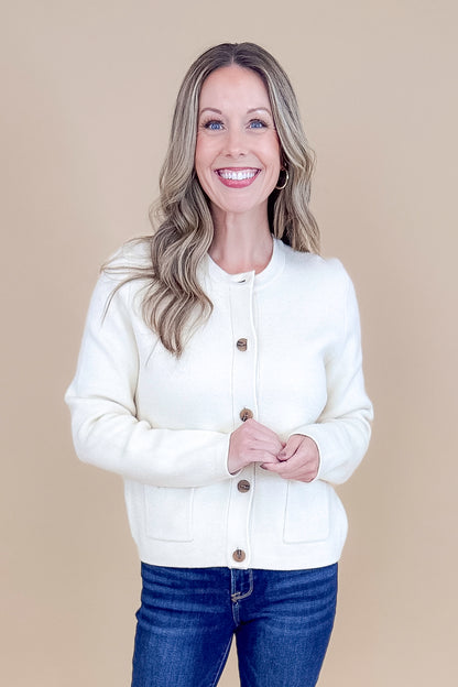 Front view of woman wearing Oatmeal Button Detail Cardigan with jeans against tan studio background.