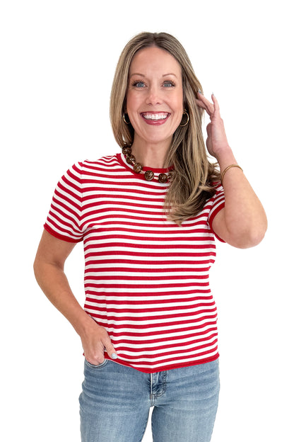 Front view of woman wearing Red &amp; White Striped Short Sleeve Sweater with jeans against white studio background.