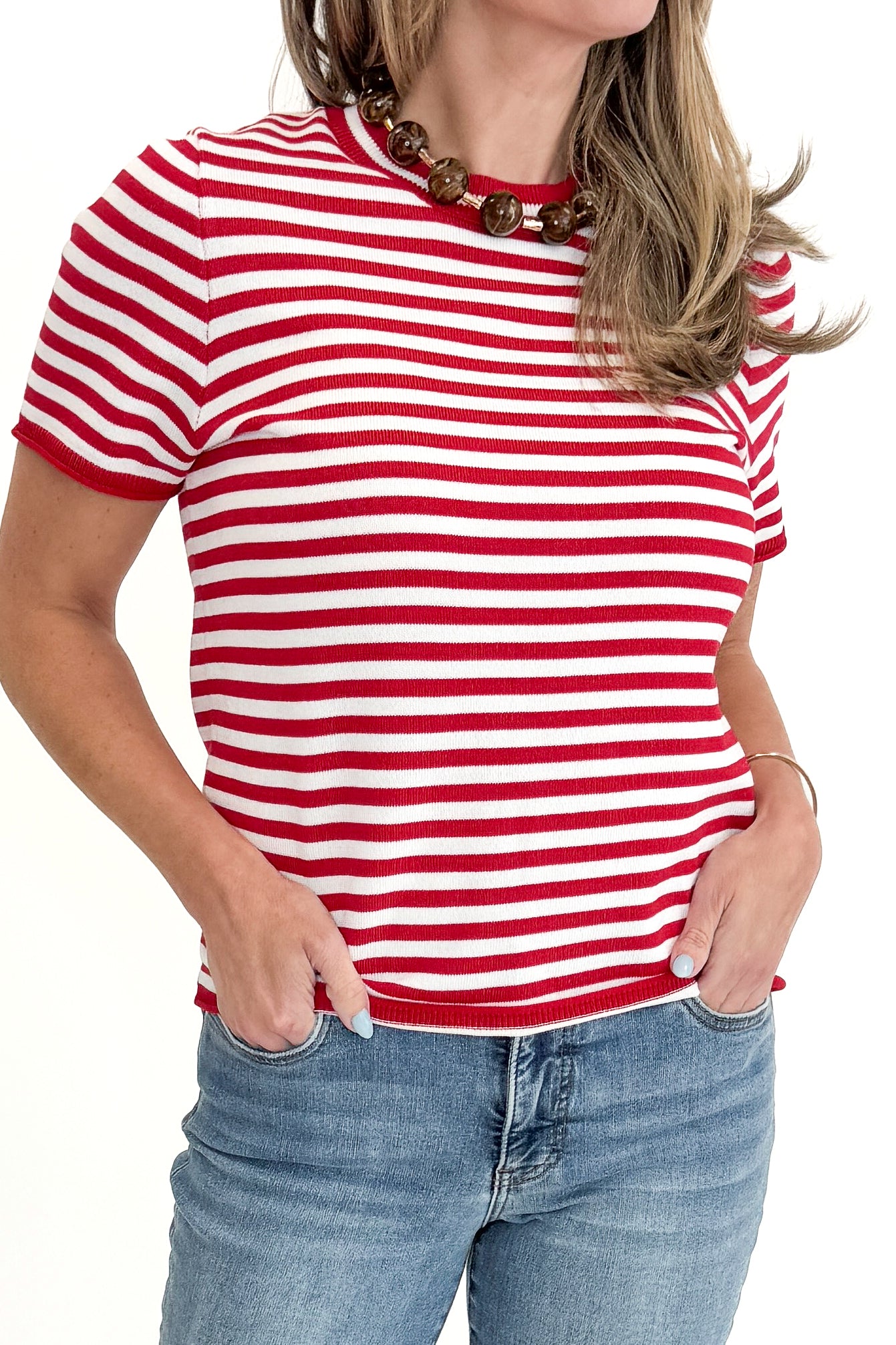 Front detail view of woman wearing Red &amp; White Striped Short Sleeve Sweater with jeans against white studio background.