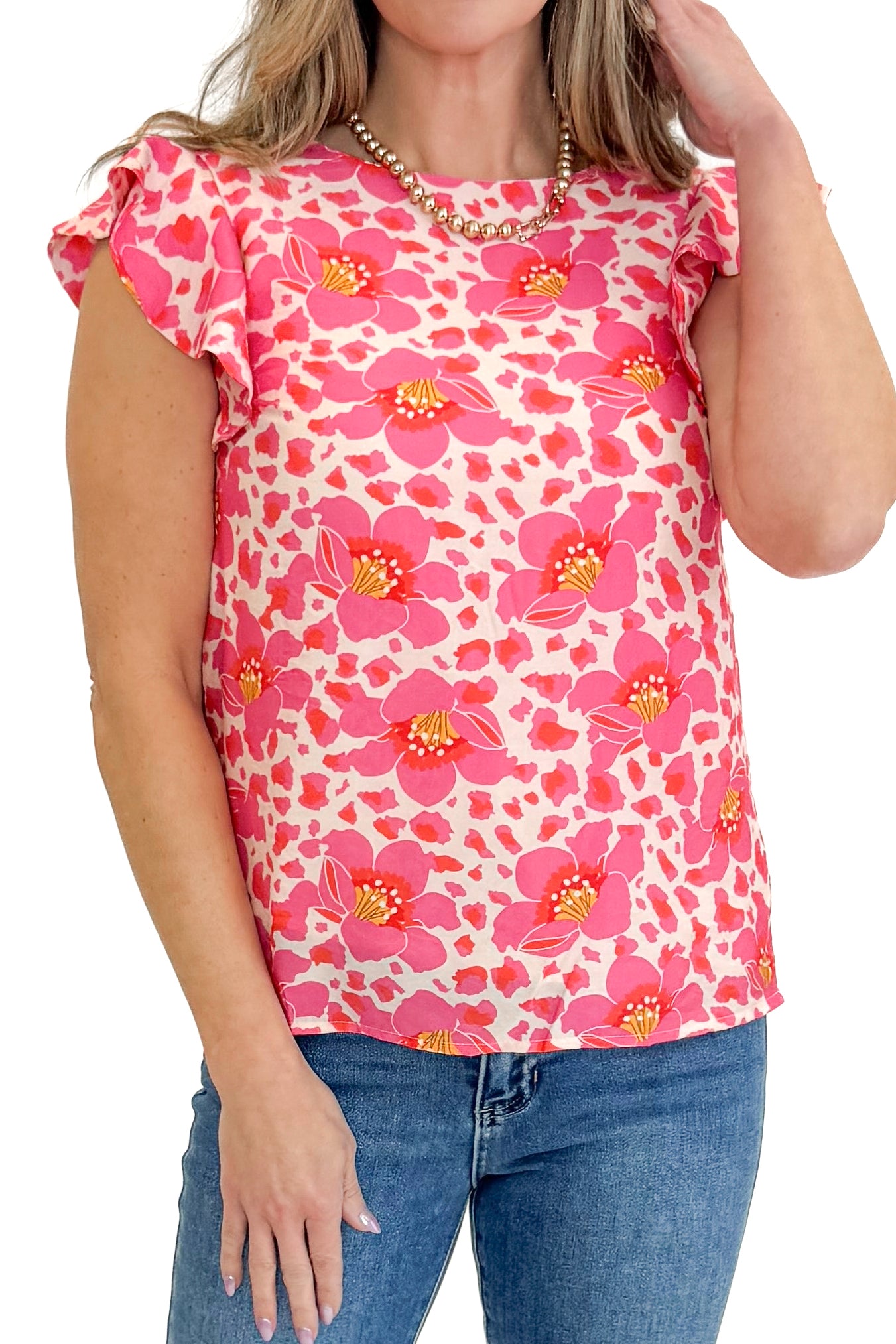 Front close view of woman wearing Pink Floral Printed Ruffle Sleeve Top with jeans against white studio background.