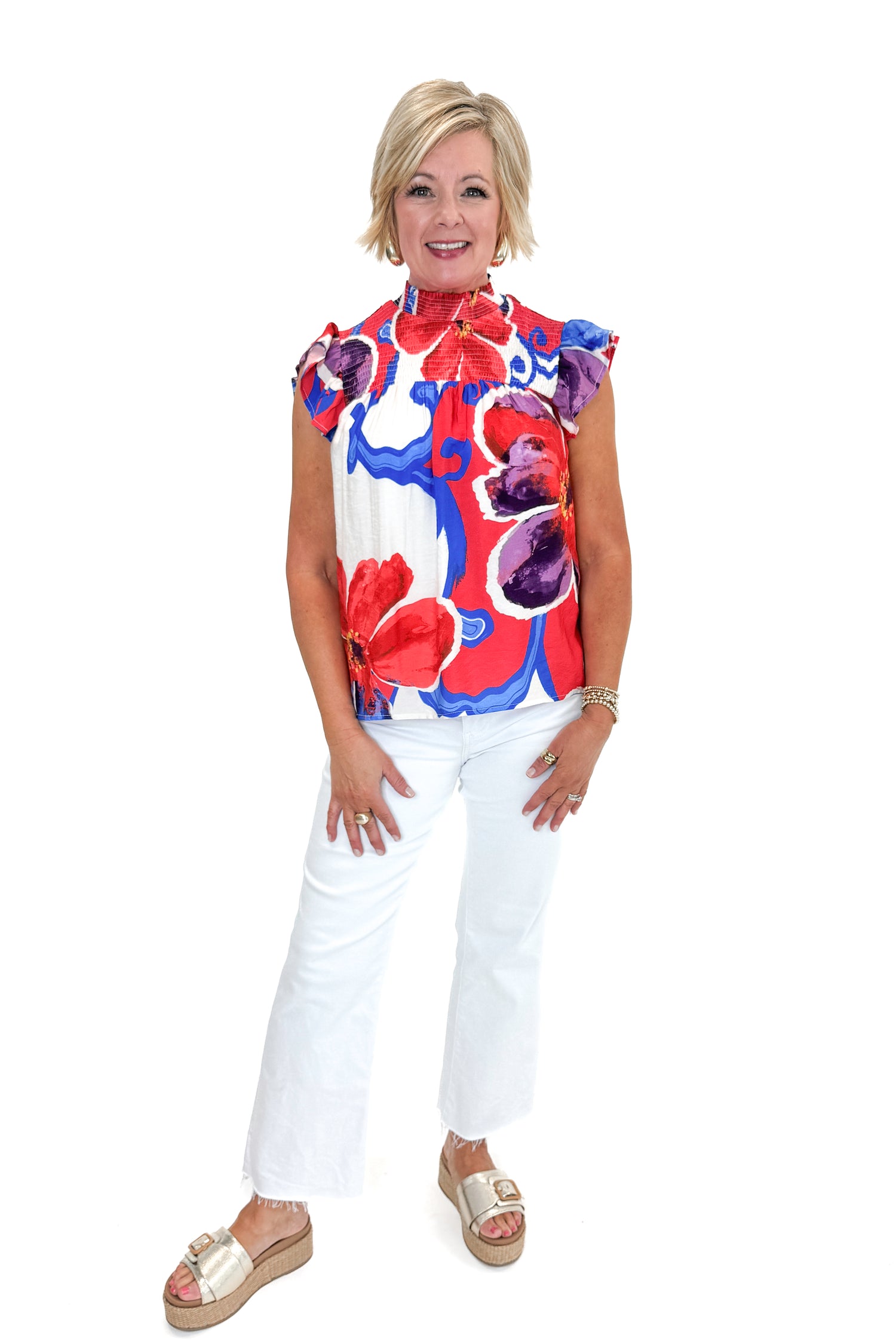Front view of woman wearing Multi Floral Smocked Detail Top with jeans against white studio background.