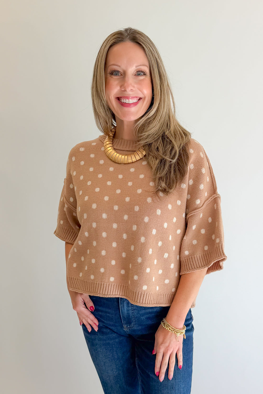 Front view of woman wearing Swagger Boutique’s Camel Polka Dot Short Sleeve Sweater by Entro with jeans against white studio background.