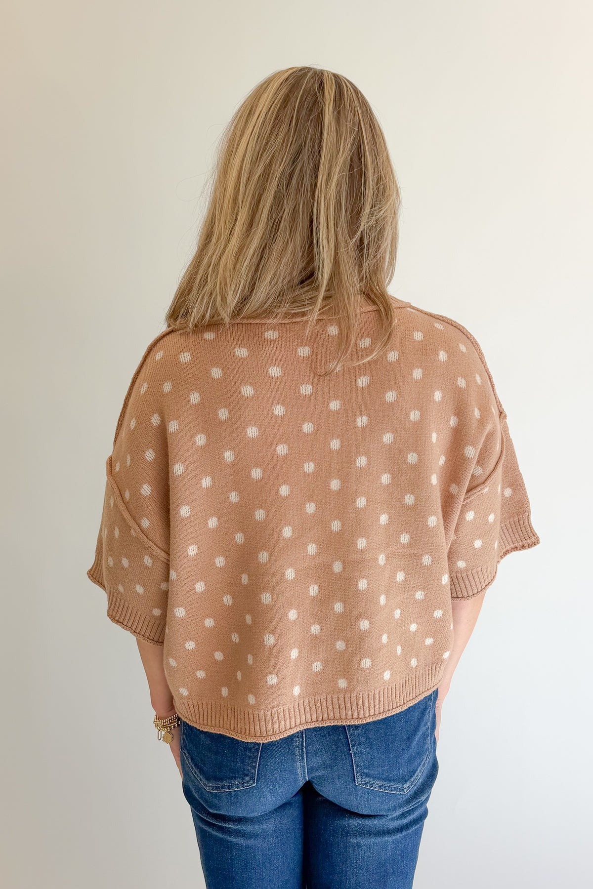 Back view of woman wearing Swagger Boutique’s Camel Polka Dot Short Sleeve Sweater by Entro with jeans against white studio background.