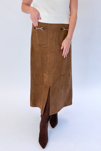 Front view of woman wearing Swagger Boutique’s White Cap Sleeve Sweater by PINCH with Camel Suede Midi Skirt With Pockets by Entro against white studio background.