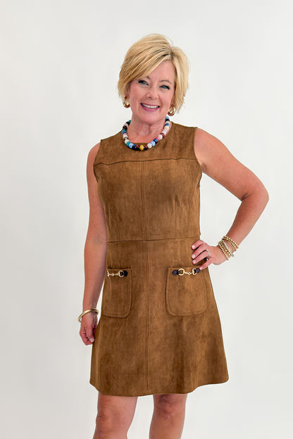 Front view of woman wearing Swagger Boutique’s Camel Suede Mini Dress With Pockets by Entro with clogs against white studio background.