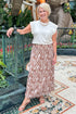 Front view of woman wearing Swagger Boutique’s Sandstone Camino Grommet Top by Z Supply with Camel Zebra Print Midi Skirt standing at a garden.