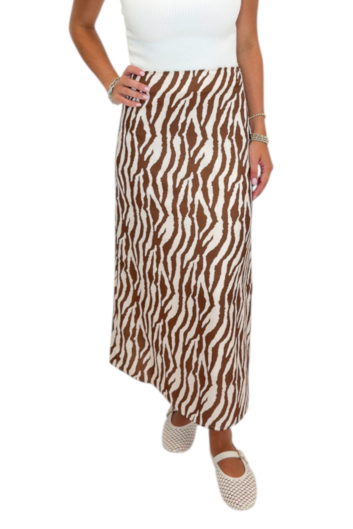 Front detail view of woman wearing Swagger Boutique’s Camel Zebra Print Midi Skirt against white studio background.