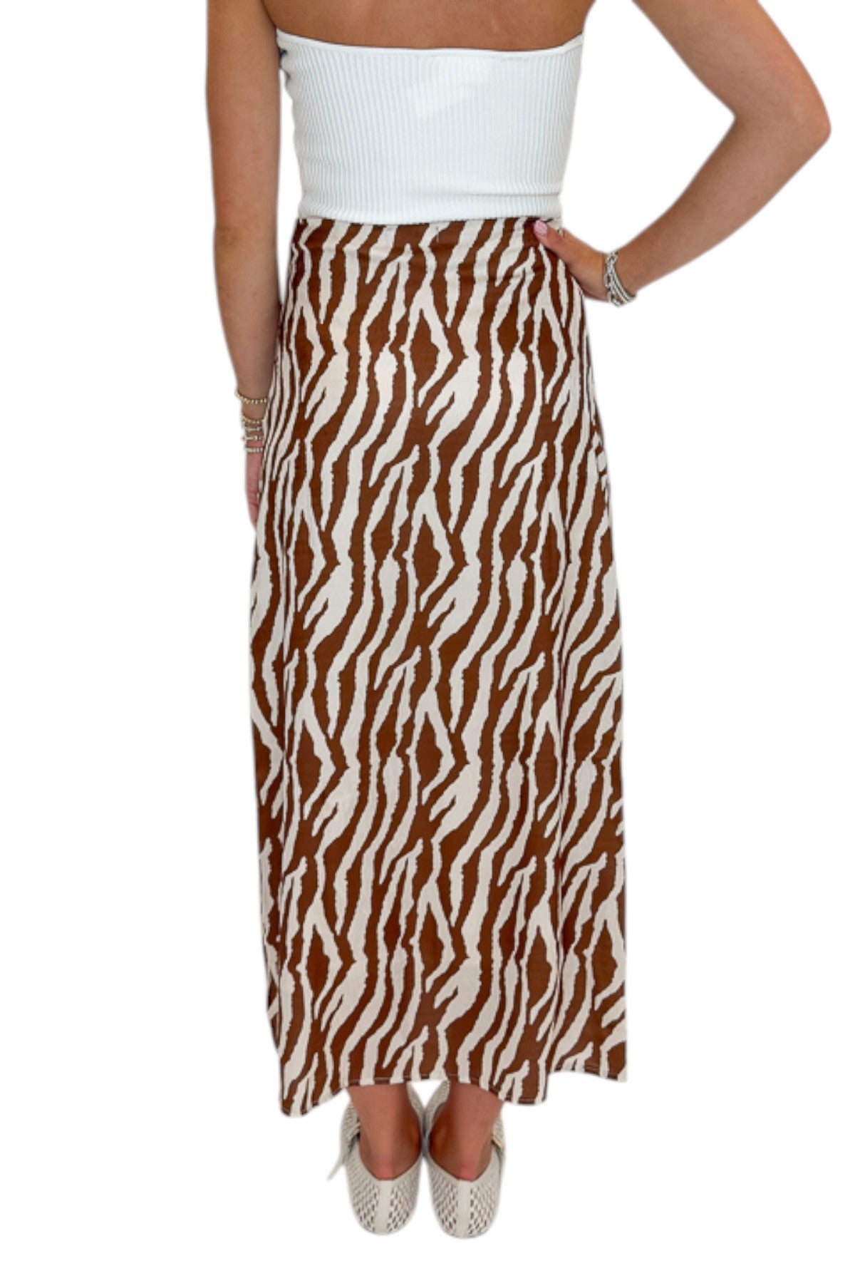 Back view of woman wearing Swagger Boutique’s  Camel Zebra Print Midi Skirt against white studio background.