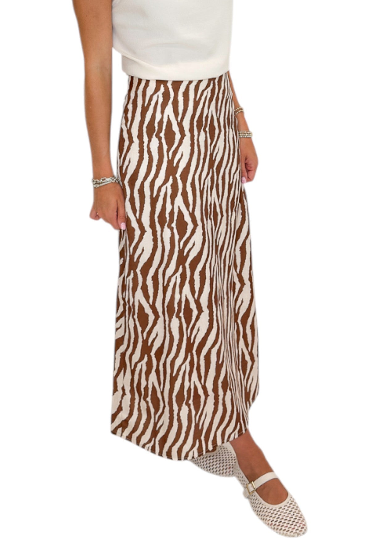 Side view of woman wearing Swagger Boutique’s Cream Cowl Neck Top with Camel Zebra Print Midi Skirt against white studio background.