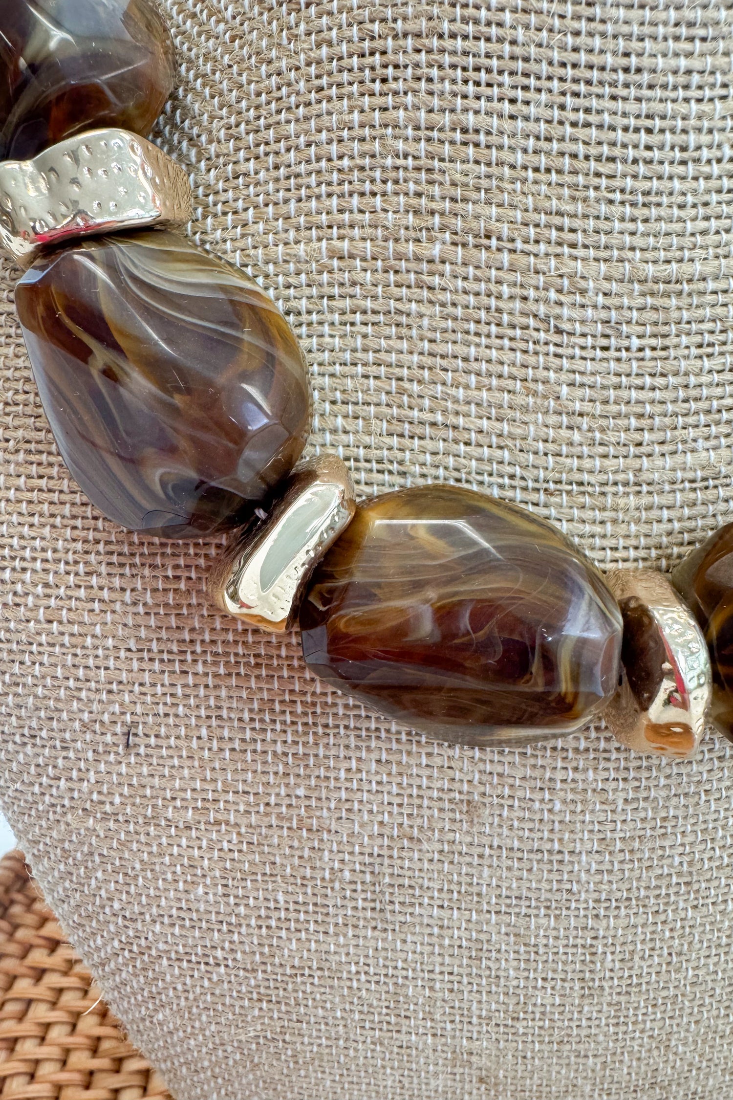 Chunky Brown Beaded Necklace with Gold Accents on a beige bust