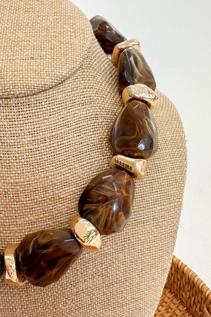 Chunky Brown Beaded Necklace with Gold Accents on a beige bust
