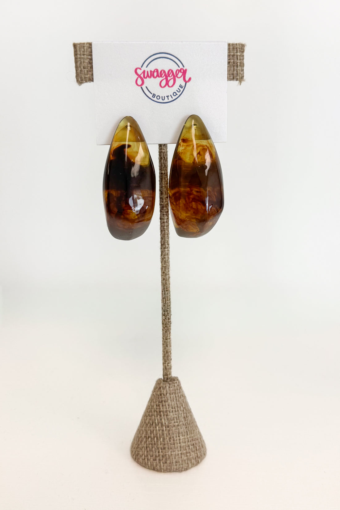 front view of brown turquiose colored hoop earrings on earrings display 