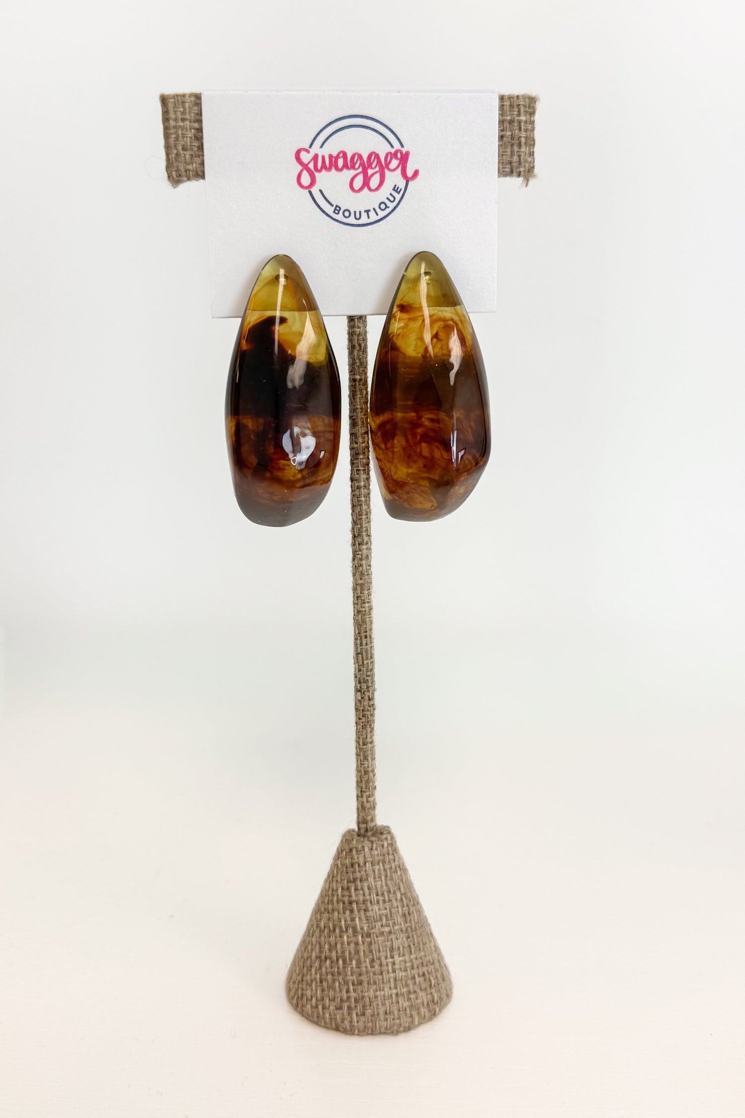 front view of brown turquiose colored hoop earrings on earrings display 