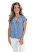 Front view of woman wearing Swagger Boutique’s Chambray Polka Dot Short Sleeve Top with jeans against white studio background.