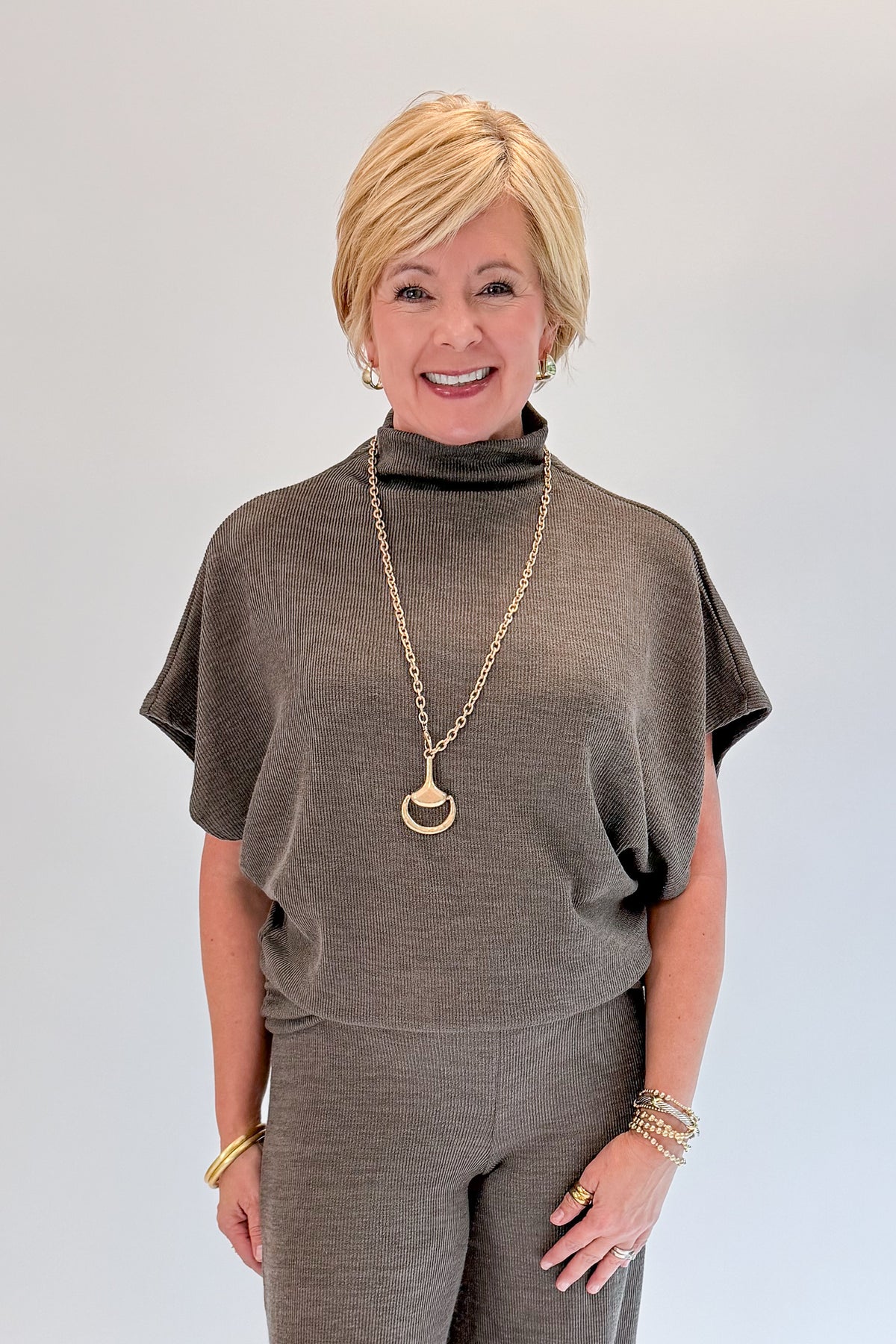 Front view of woman wearing Swagger Boutique’s Charcoal Ribbed Short Sleeve Turtleneck Top &amp; Lounge Pants against white studio background.