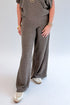 Front detail view of woman wearing Swagger Boutique’s Charcoal Ribbed Short Sleeve Turtleneck Top & Lounge Pants against white studio background.