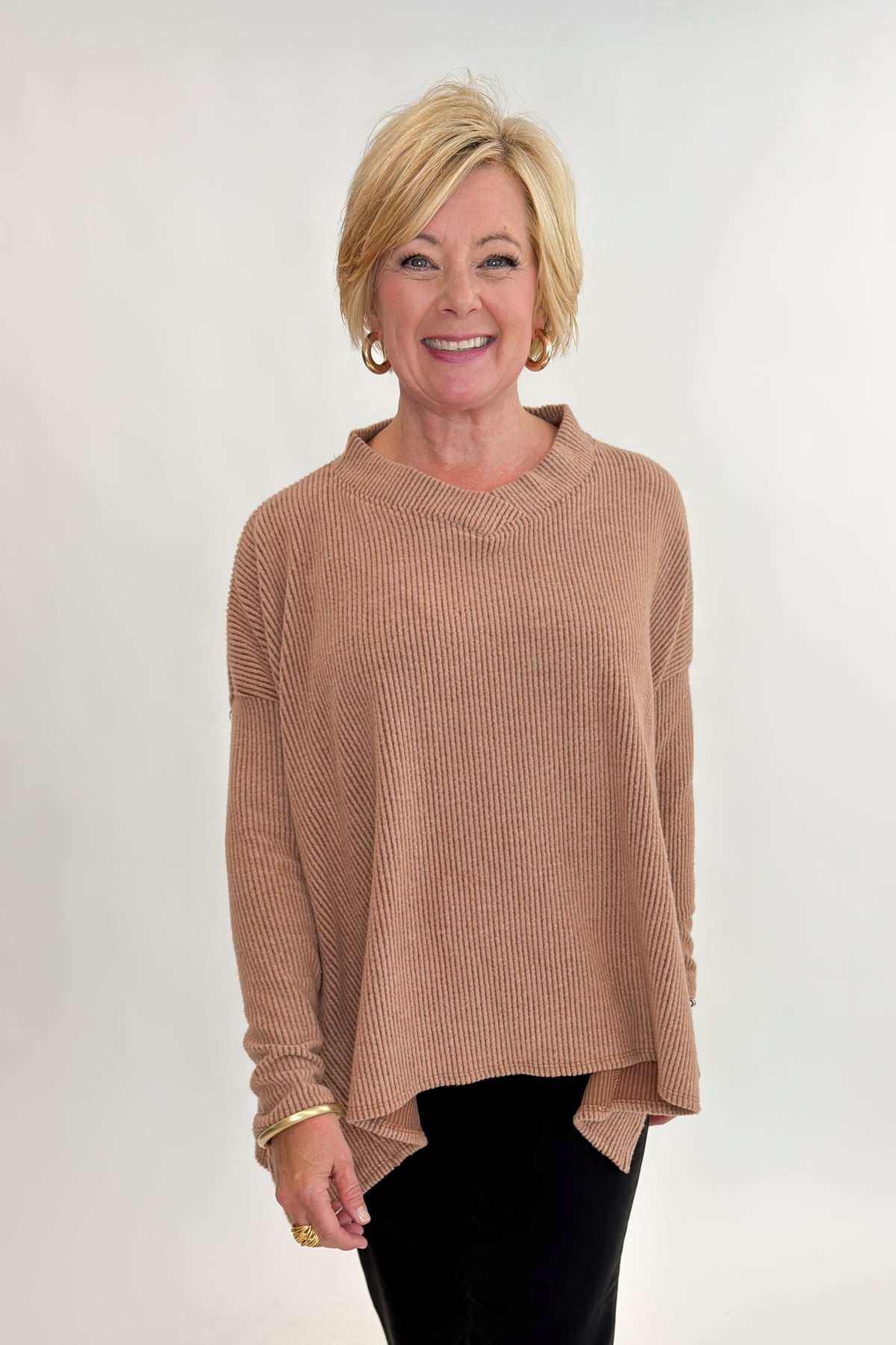 Front view of woman wearing Swagger Boutique’s Chestnut Brushed V-neck Top with jeans against white studio background.