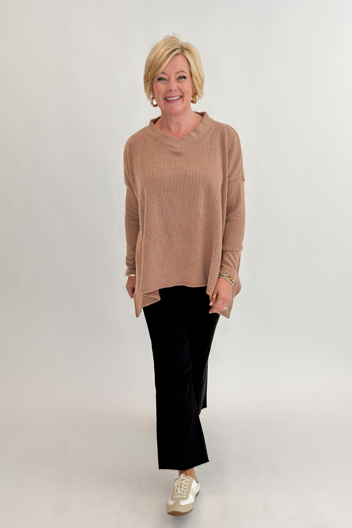 Front view of woman wearing Swagger Boutique’s Chestnut Brushed V-neck Top with jeans against white studio background.