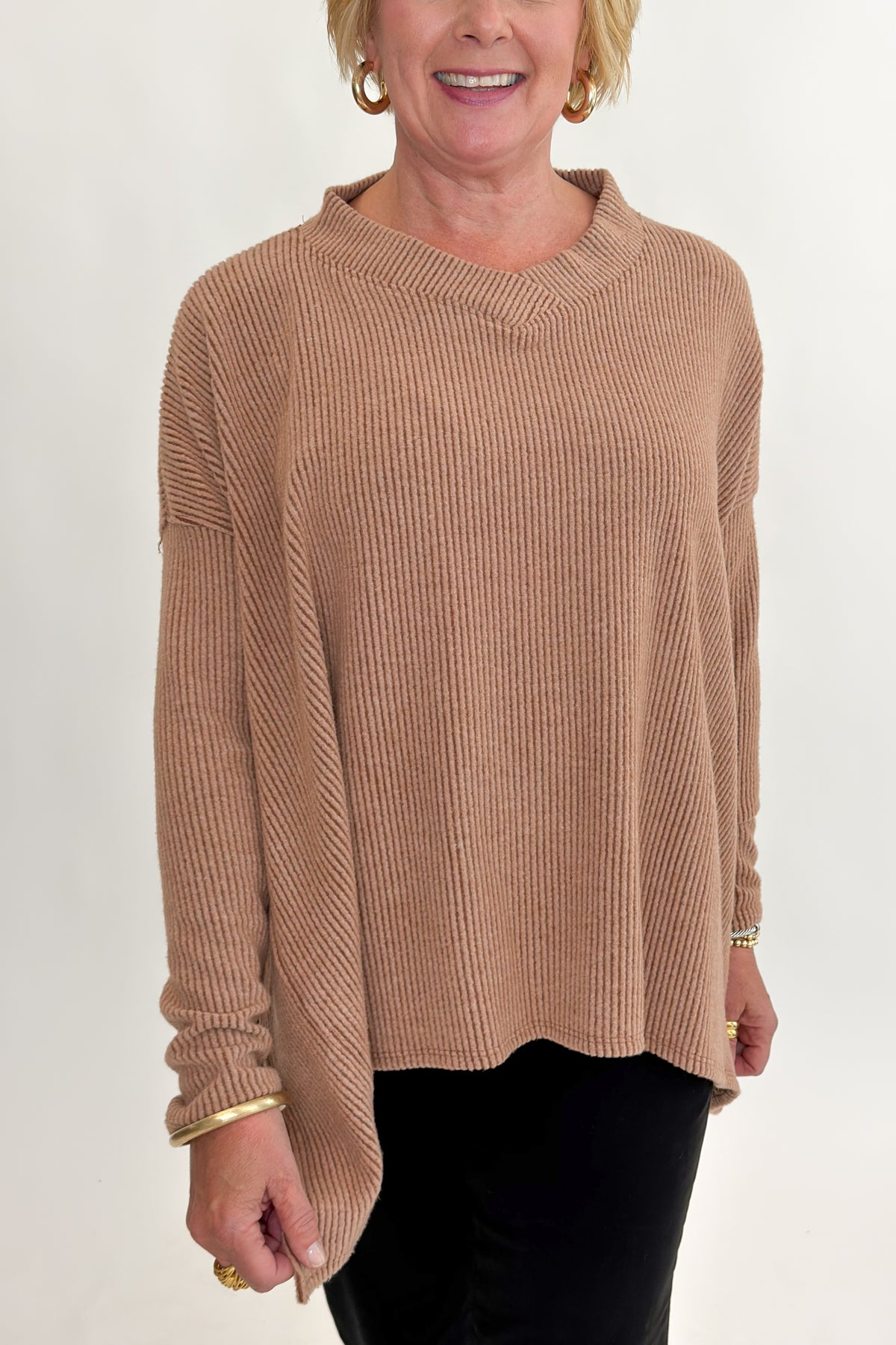 Front detail view of woman wearing Swagger Boutique’s Chestnut Brushed V-neck Top with jeans against white studio background.