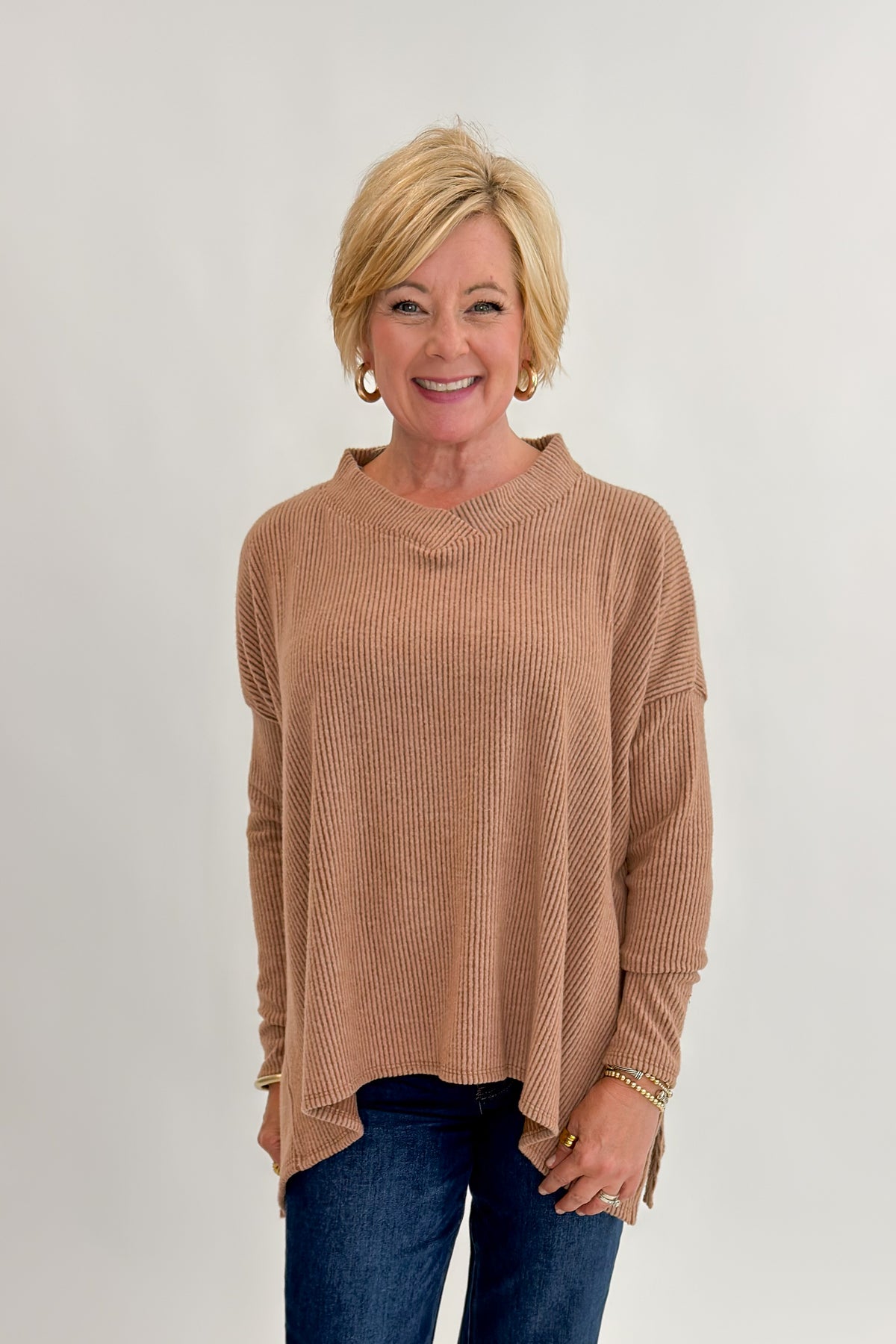 Front view of woman wearing Swagger Boutique’s Chestnut Brushed V-neck Top with jeans against white studio background.