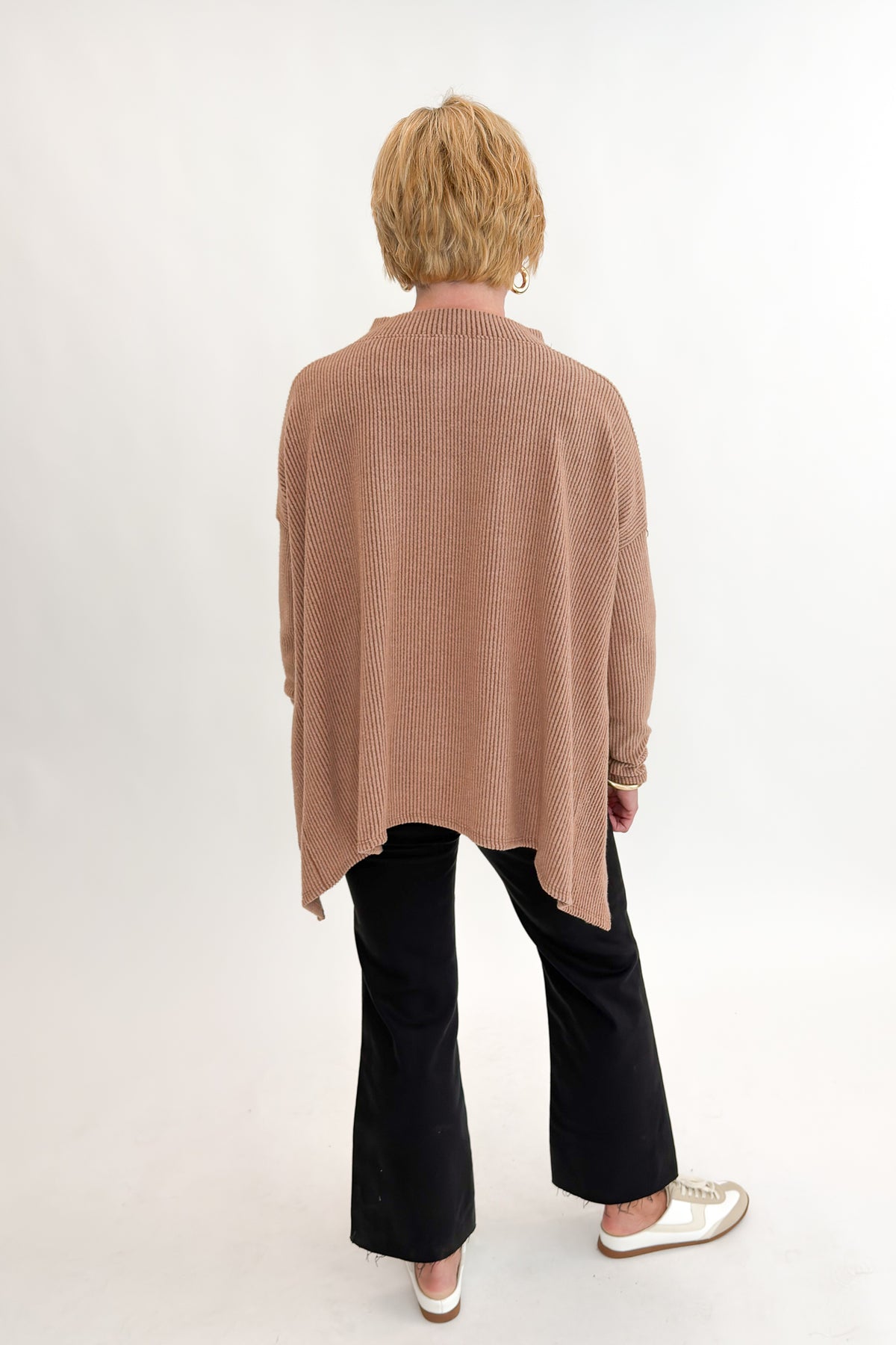 Back view of woman wearing Swagger Boutique’s Chestnut Brushed V-neck Top with jeans against white studio background.