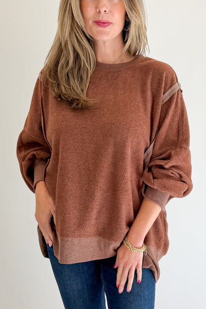 Front detail view of woman wearing Swagger Boutique’s Chestnut Seam Detail Sweatshirt with jeans against white studio background.