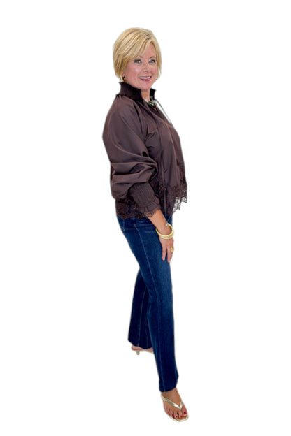 Side view of woman wearing Swagger Boutique’s Chocolate Lace Lined Top by Entro with jeans against white studio background.